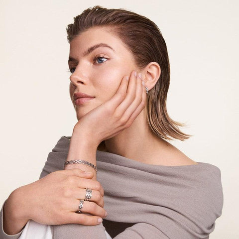 Elegant Daniel Wellington 5-Link silver stainless steel ring worn on a model's finger for a sophisticated, modern look.