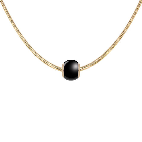 Daniel Wellington gold-plated snake chain necklace featuring a sleek, black ceramic orb charm.