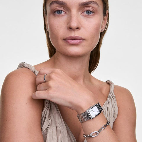 Daniel Wellington silver crystal link bracelet layered with a matching watch on a woman's wrist.