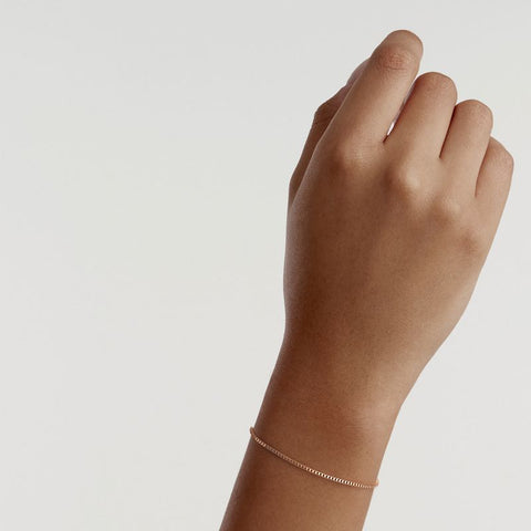 Elegant Daniel Wellington Elan box chain bracelet in rose gold-plated stainless steel worn on a wrist.