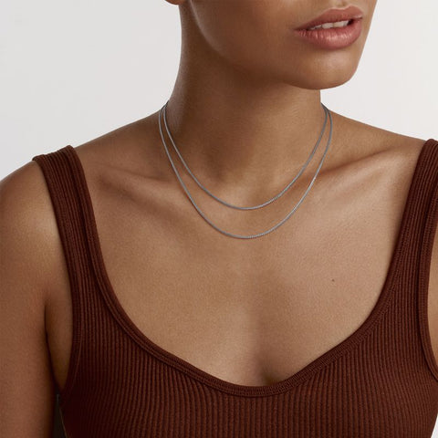 Elegant Daniel Wellington Elan box chain necklace in polished silver stainless steel worn as a delicate double layer.