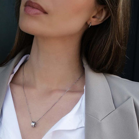 Minimalist Daniel Wellington Elan earrings in silver stainless steel with subtle logo engraving worn as everyday essentials.