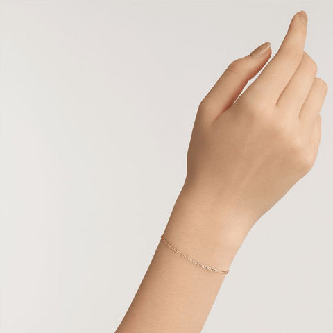 Elegant Daniel Wellington Elan flat chain bracelet in gold-plated stainless steel worn on a wrist.