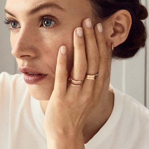 Elegant rose gold plated stainless steel Elan ring with a sleek, minimalist silhouette worn on a woman's hand.