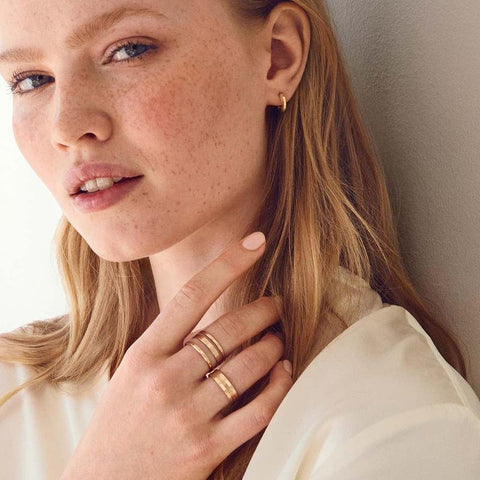 Elegant Daniel Wellington Elan Triad ring in rose gold-plated stainless steel worn on a woman's finger.