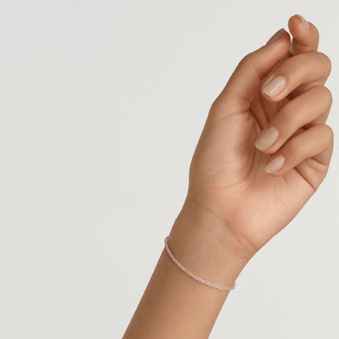Elegant Daniel Wellington Elan twisted chain bracelet in polished silver stainless steel worn on a wrist.
