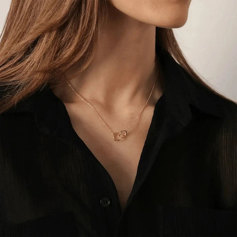 Elegant rose gold Daniel Wellington Elan Unity necklace featuring two interlocking rings on a delicate chain.