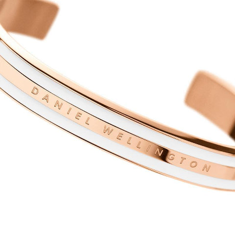 Daniel Wellington Emalie cuff bracelet in rose gold stainless steel with a sleek white enamel inlay and engraved logo.