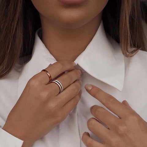 Elegant Daniel Wellington Emalie ring in rose gold and white enamel, featuring a refined engraved logo design.