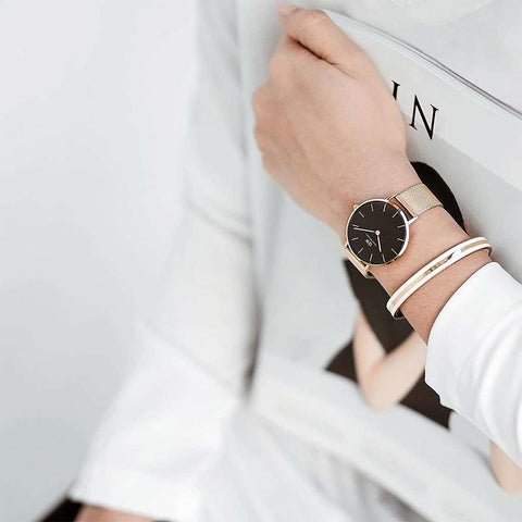Elegant rose gold Daniel Wellington Emalie Slim cuff bangle with white enamel inlay and subtle logo engraving.