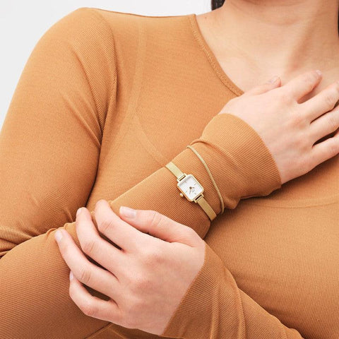 Elegant gold Evergold mesh bracelet paired with a matching Daniel Wellington watch on a wrist.