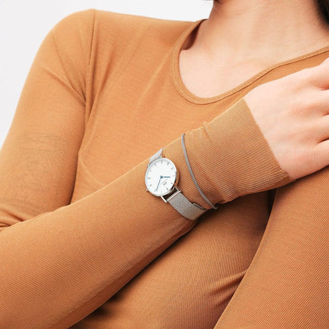 Daniel Wellington silver stainless steel mesh bracelet paired with a matching watch on a wrist.