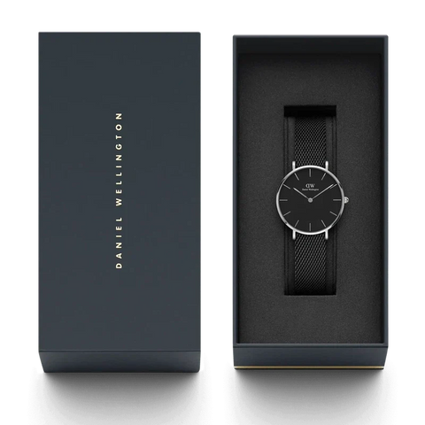 Daniel Wellington Petite Ashfield 28mm watch with a black mesh strap and silver case in a premium gift box.