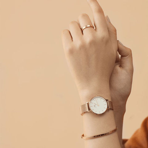 Daniel Wellington Petite Melrose 24mm watch with an elegant rose gold mesh strap and classic eggshell white dial.