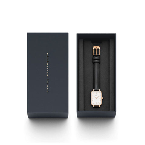 Daniel Wellington Quadro watch with a rose gold square case, eggshell white dial, and black leather strap in a gift box.