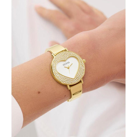 The Watch Boutique Guess Ladies Gold Tone Analog Watch with Heart‑Shaped Sunray Dial