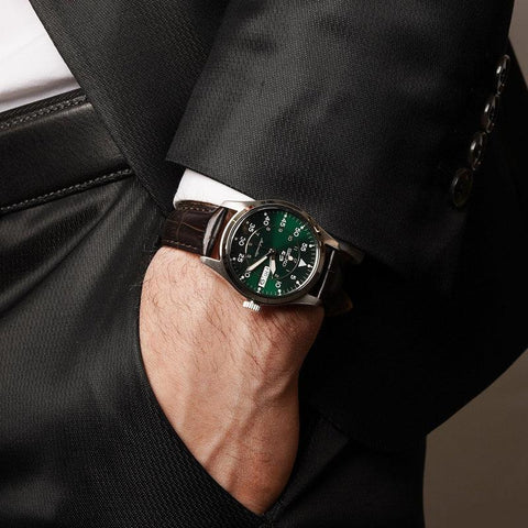 Seiko 5 Sports 36mm field watch with a kelly green dial and brown leather strap worn with a formal suit.